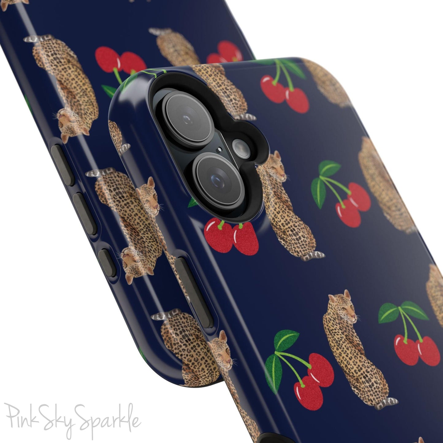 A stylish magnetic iPhone case featuring a unique pattern of leopards and bright red cherries on a dark navy blue background, blending bold and playful elements.