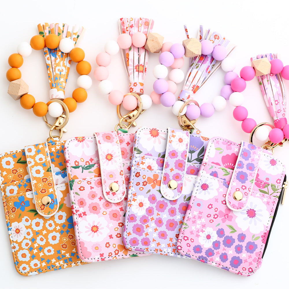 View of four variants of the floral wristlet card holder with beaded keychain, tassel, and zipper pocket – compact wallet for women
