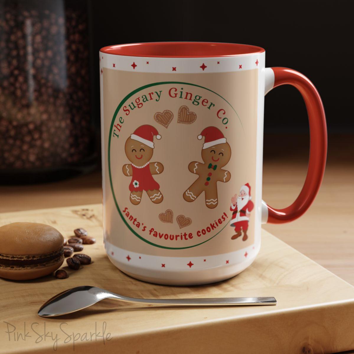 Holiday Gingerbread Coffee Mug featuring a male and female gingerbread cookies next to Santa with giving a thumbs up and the writing The Sugary Ginger Co. written at the top and Santa's favourite cookies at the bottom. The mug has a red handle and red interior.