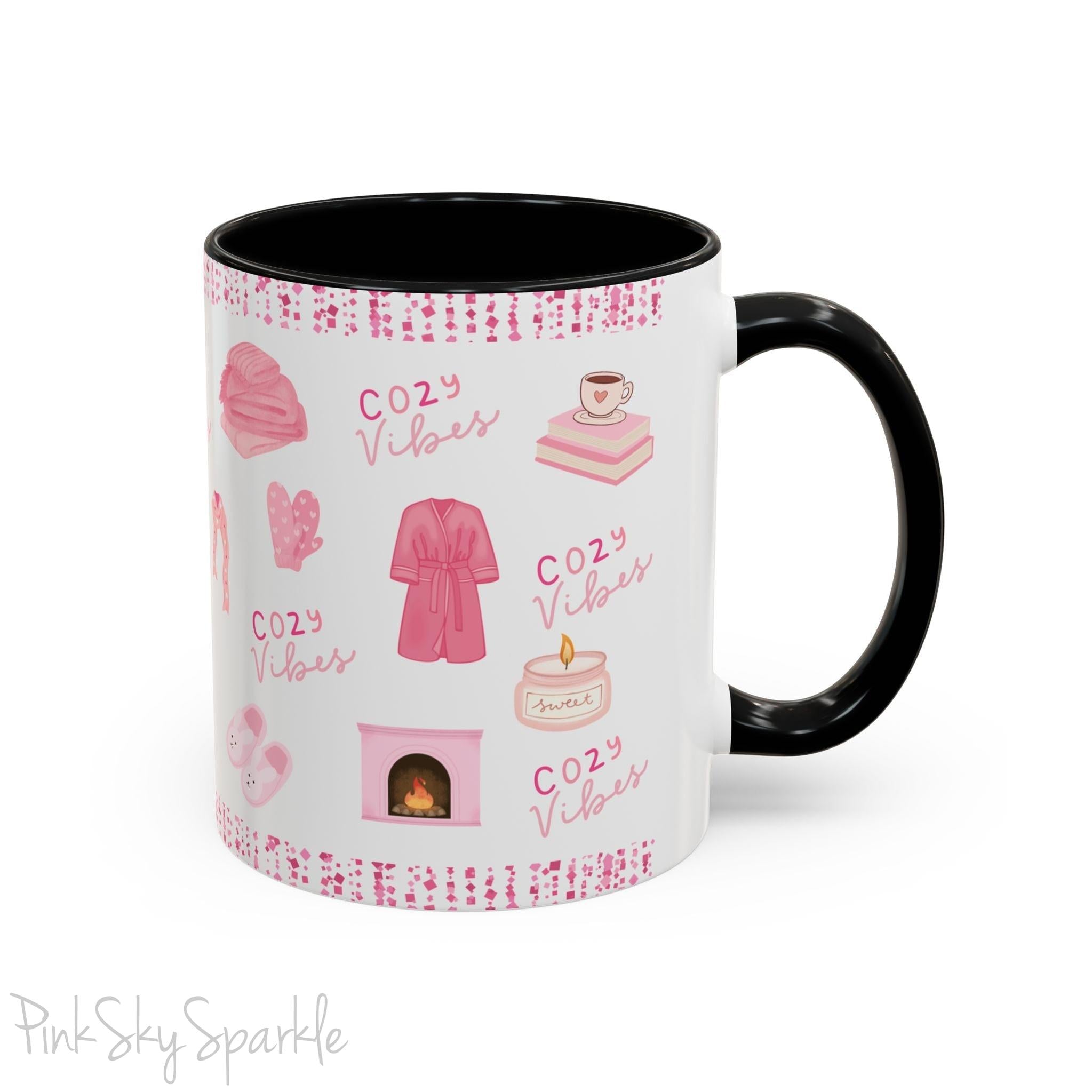 Pink Cozy Vibes Mug - Perfect for coffee, tea, or hot cocoa lovers! This ceramic mug features 'cozy vibes' in a pink font, surrounded by cute illustrations of pink cozy items such as slippers, mittens, blankets and candles. Ideal for creating a warm, cozy atmosphere, this pink-handled mug (also available in light blue, black and navy) makes a great gift for anyone who loves comfort, style and the color pink.
