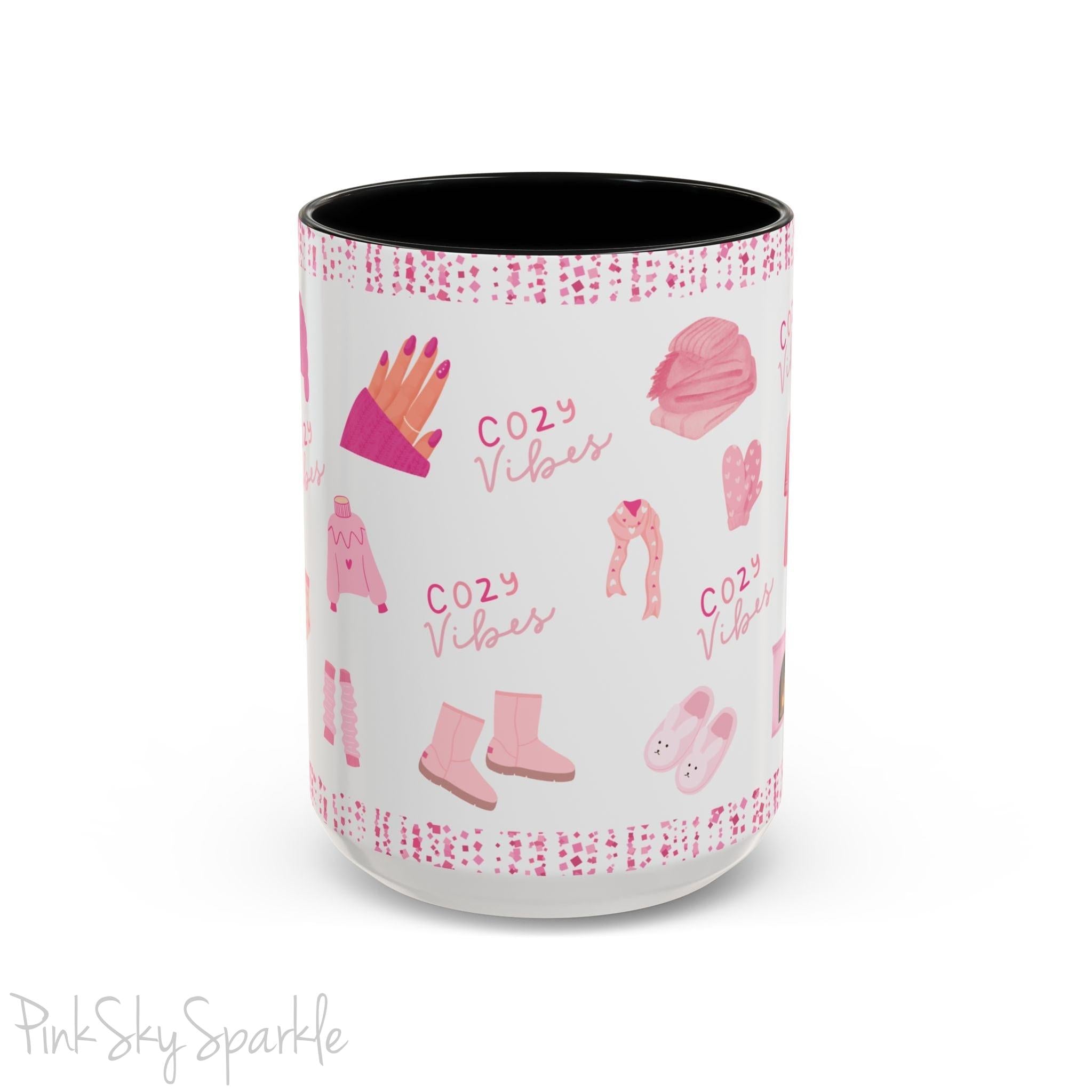 Pink Cozy Vibes Mug - Perfect for coffee, tea, or hot cocoa lovers! This ceramic mug features 'cozy vibes' in a pink font, surrounded by cute illustrations of pink cozy items such as slippers, mittens, blankets and candles. Ideal for creating a warm, cozy atmosphere, this pink-handled mug (also available in light blue, black and navy) makes a great gift for anyone who loves comfort, style and the color pink.