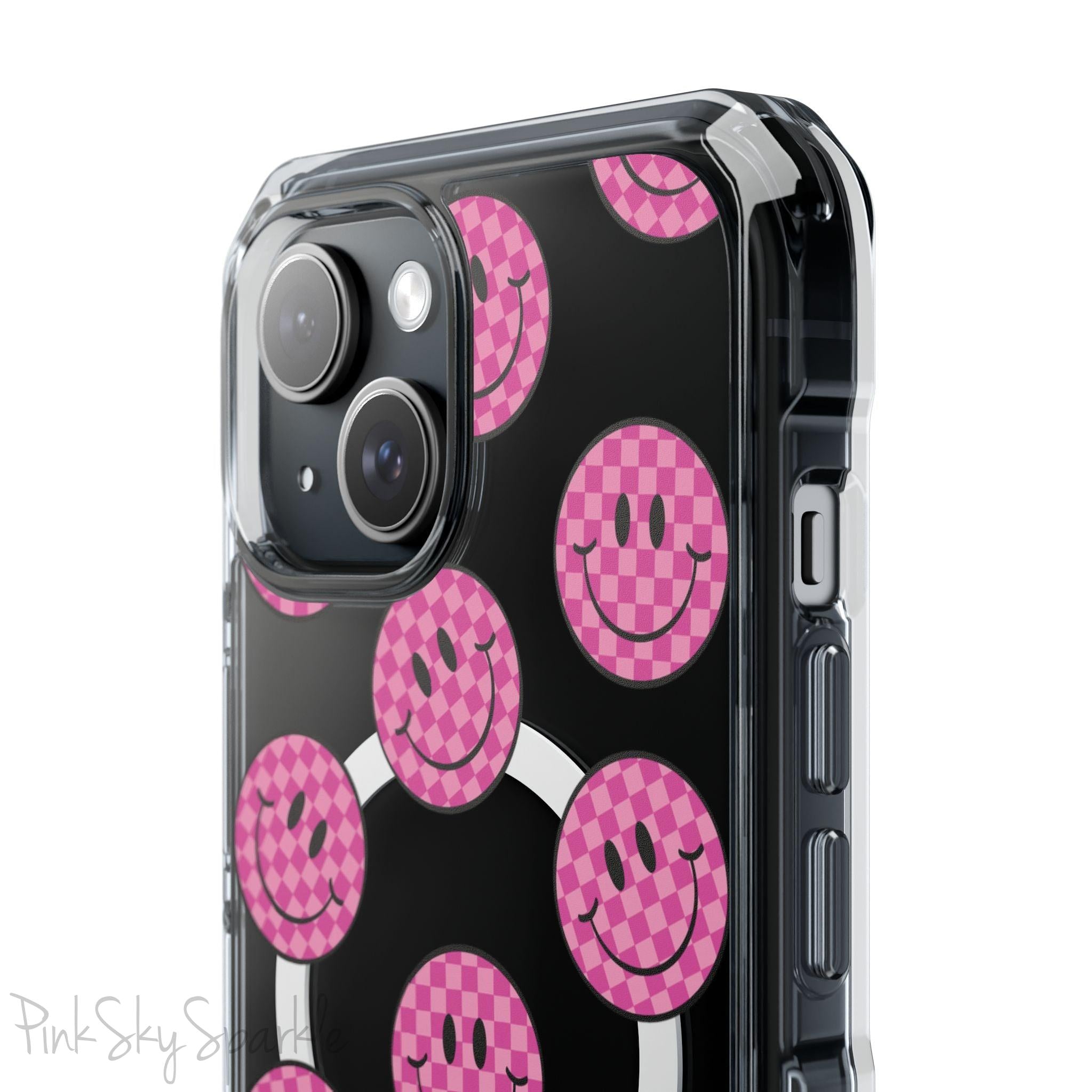 Clear magnetic phone case featuring pink checkered smiley faces on a transparent background, designed for MagSafe® compatibility with air-cushioned bumper corners.