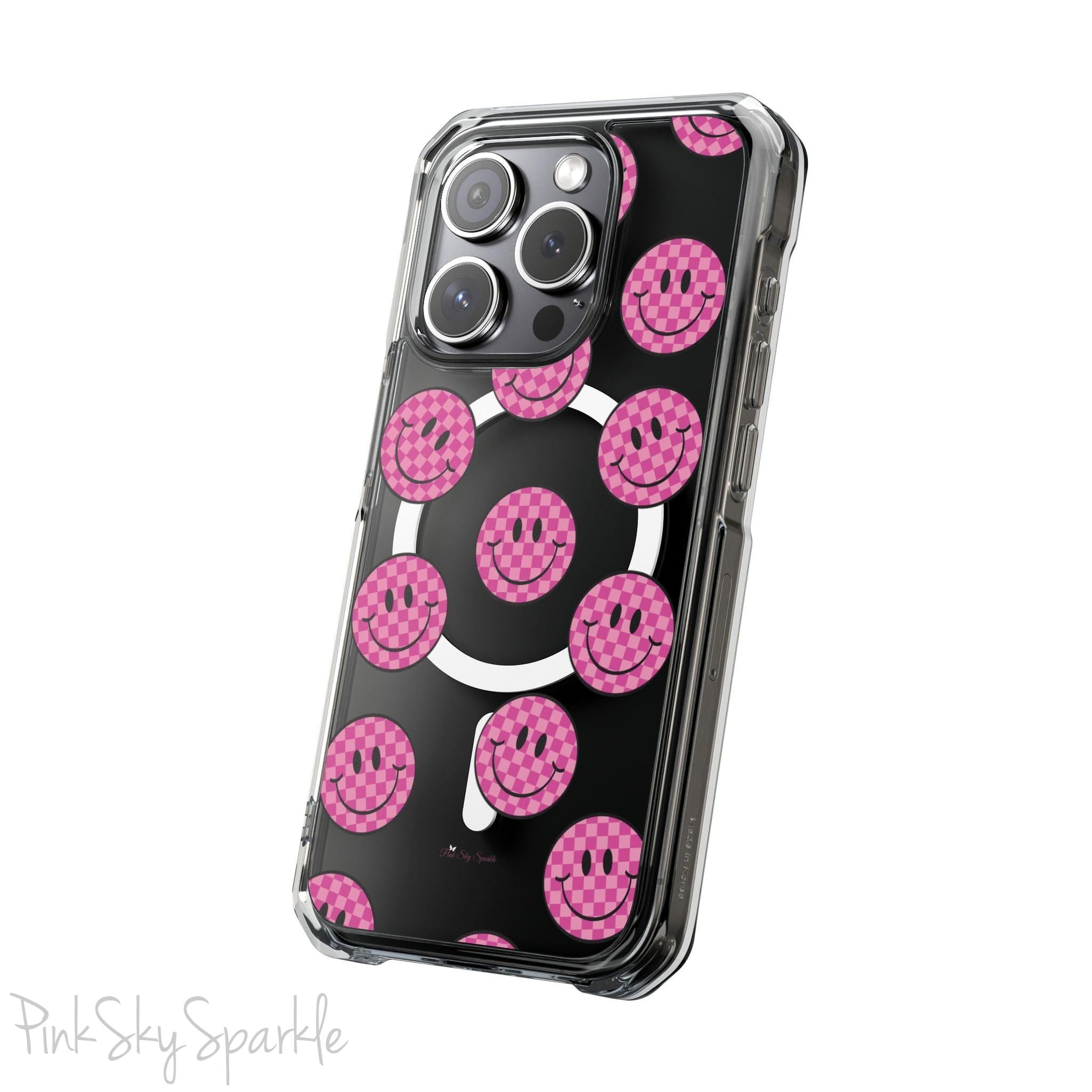 Clear magnetic phone case featuring pink checkered smiley faces on a transparent background, designed for MagSafe® compatibility with air-cushioned bumper corners.