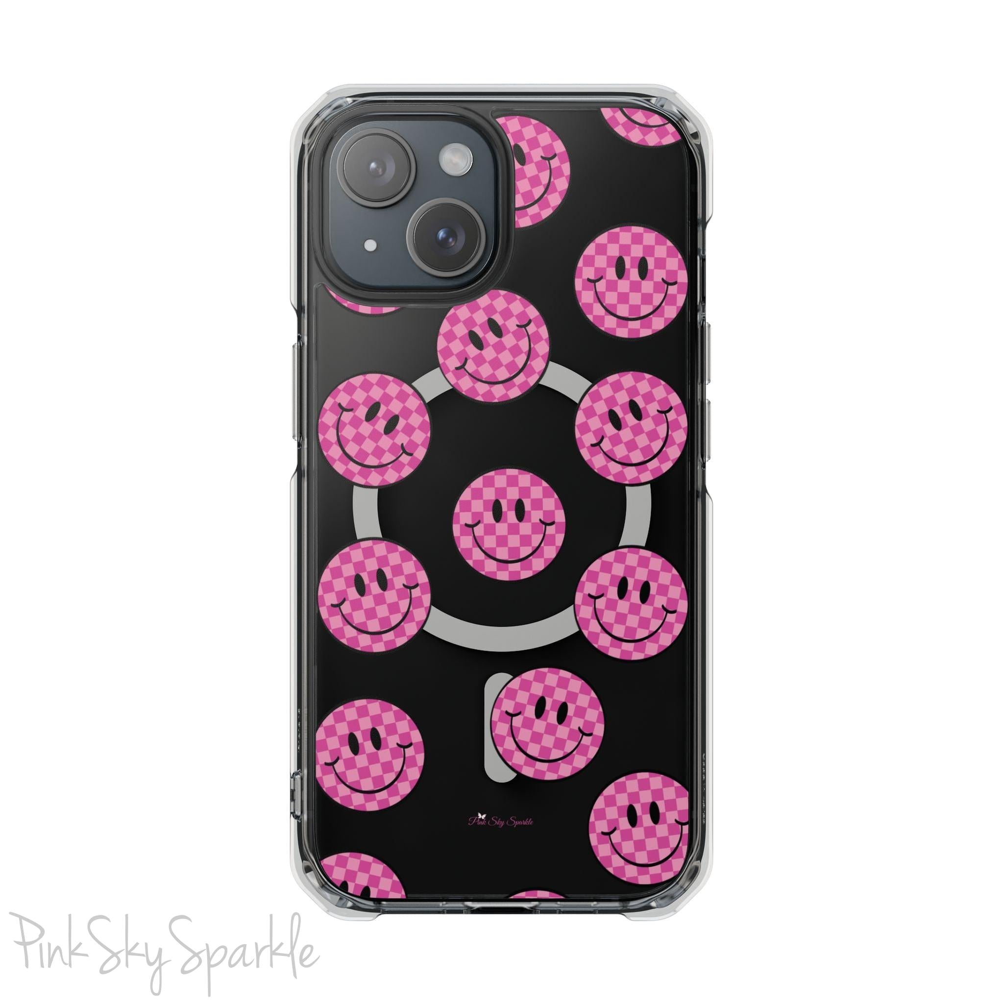 Clear magnetic phone case featuring pink checkered smiley faces on a transparent background, designed for MagSafe® compatibility with air-cushioned bumper corners.