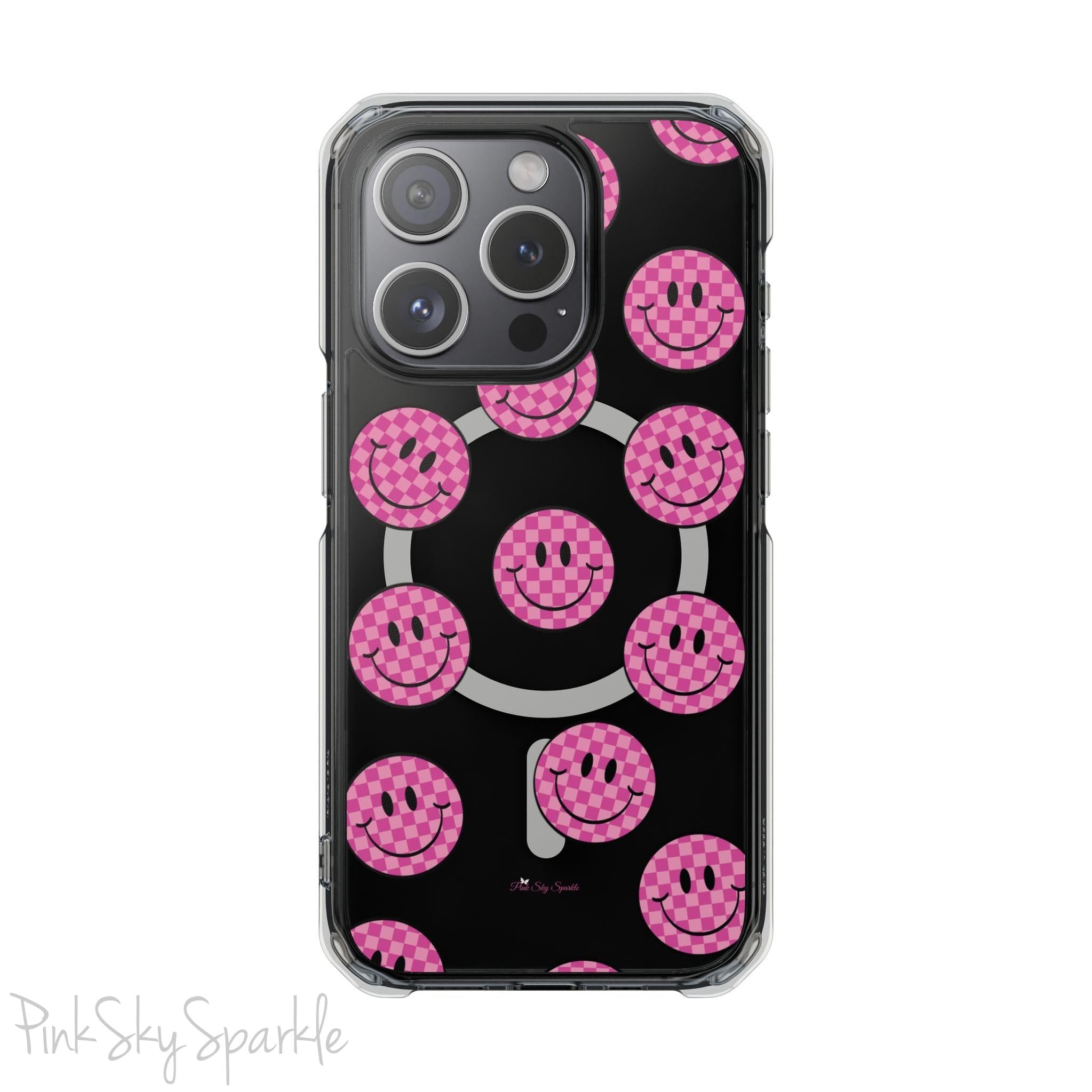 Clear magnetic phone case featuring pink checkered smiley faces on a transparent background, designed for MagSafe® compatibility with air-cushioned bumper corners.