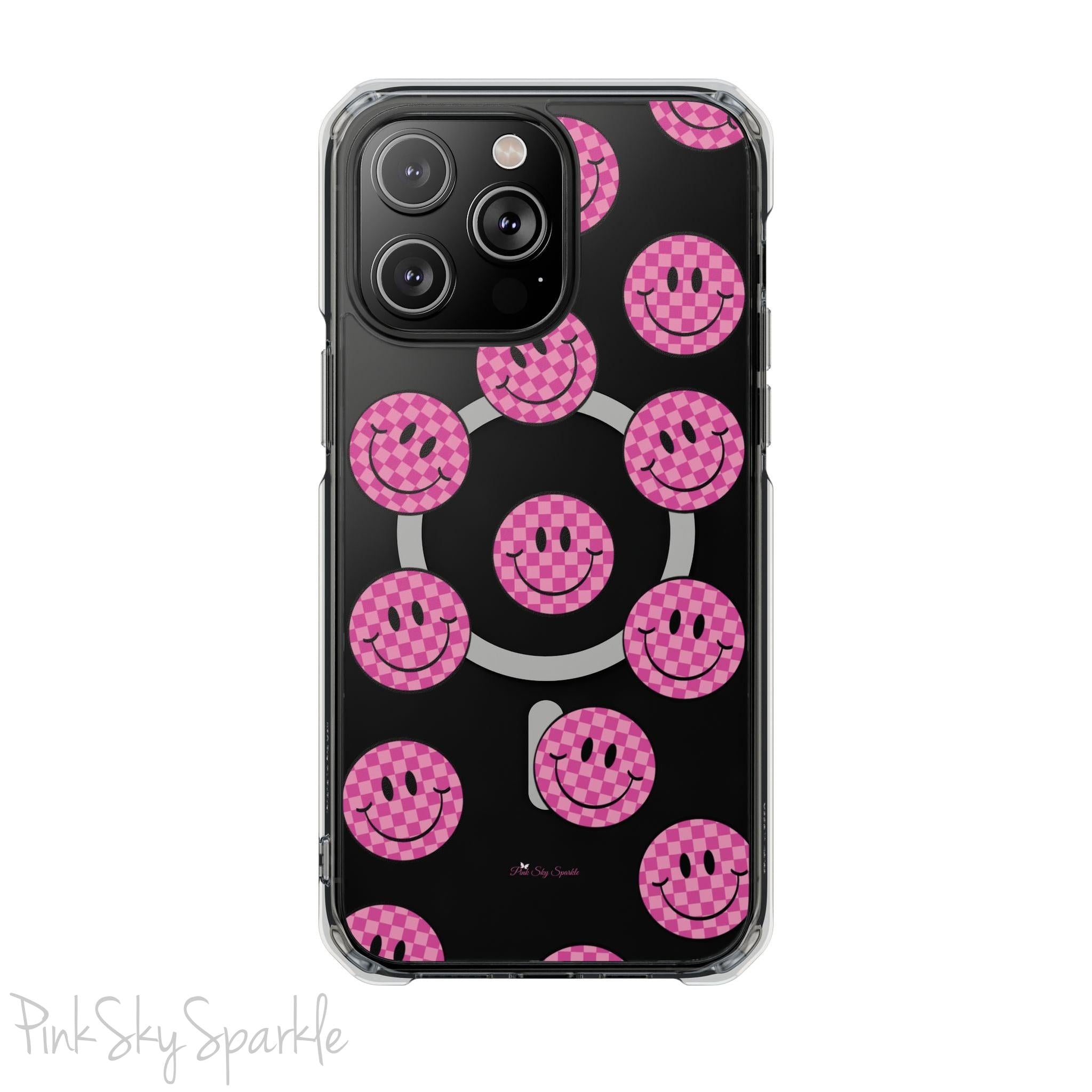 Clear magnetic phone case featuring pink checkered smiley faces on a transparent background, designed for MagSafe® compatibility with air-cushioned bumper corners.