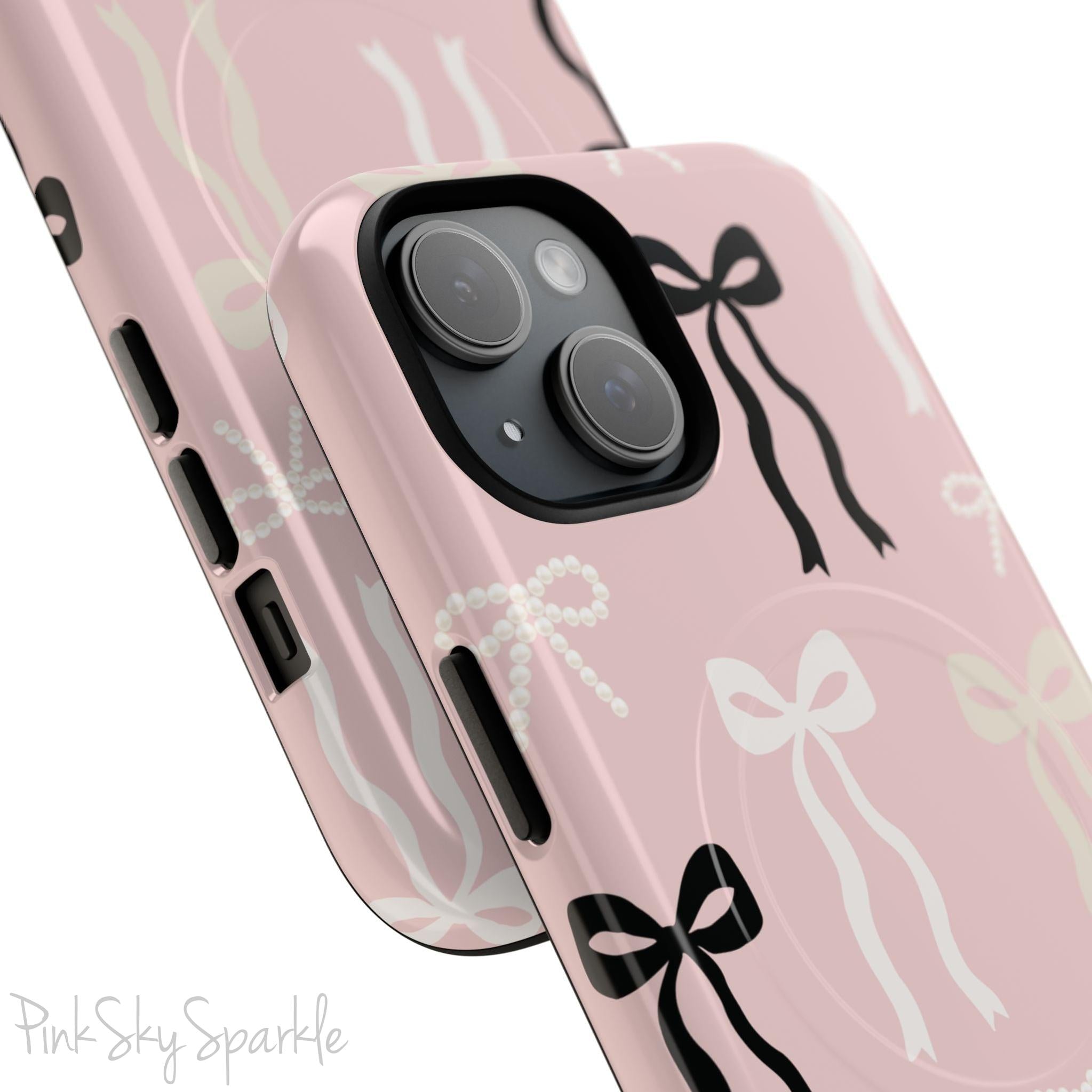 Pink magnetic iPhone case featuring an elegant bow pattern with black, white, and cream bows, designed for MagSafe® compatibility and premium protection.