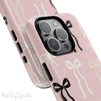 Pink magnetic iPhone case featuring an elegant bow pattern with black, white, and cream bows, designed for MagSafe® compatibility and premium protection.