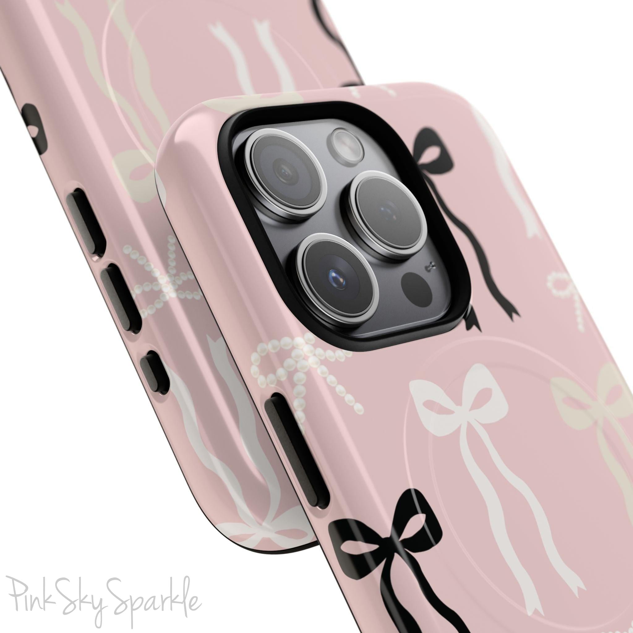 Pink magnetic iPhone case featuring an elegant bow pattern with black, white, and cream bows, designed for MagSafe® compatibility and premium protection.