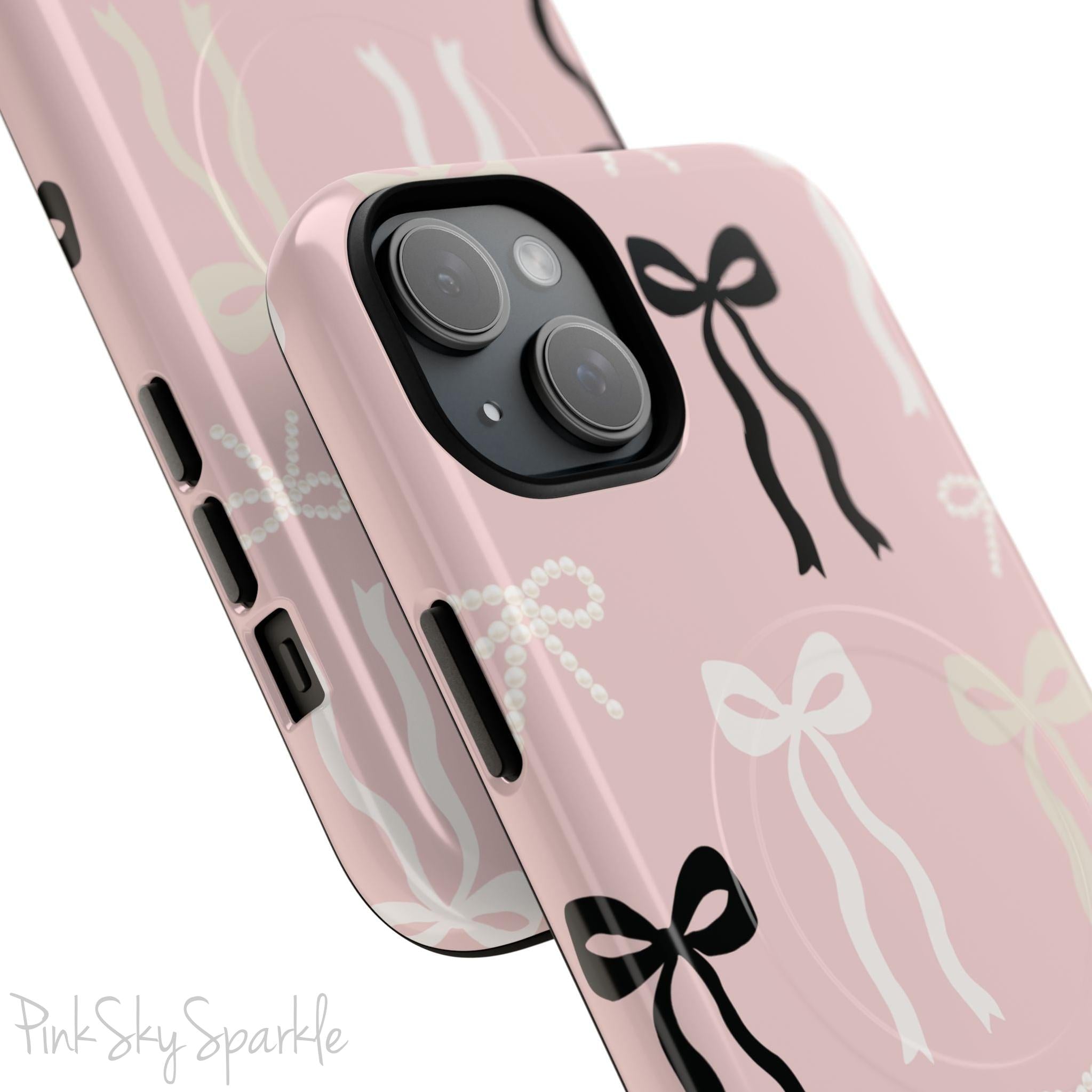Pink magnetic iPhone case featuring an elegant bow pattern with black, white, and cream bows, designed for MagSafe® compatibility and premium protection.
