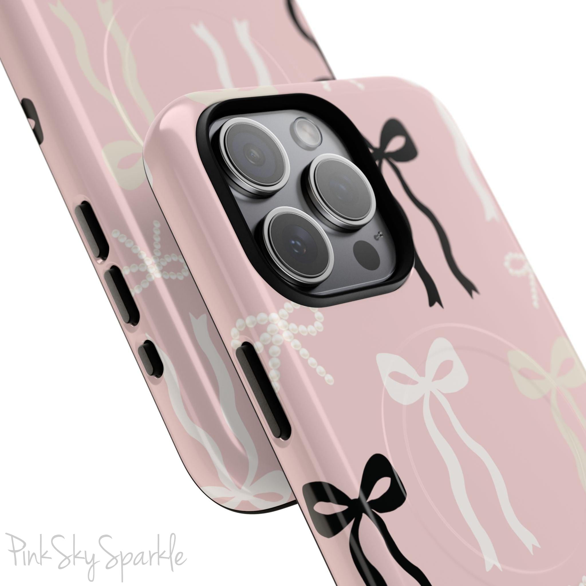 Pink magnetic iPhone case featuring an elegant bow pattern with black, white, and cream bows, designed for MagSafe® compatibility and premium protection.