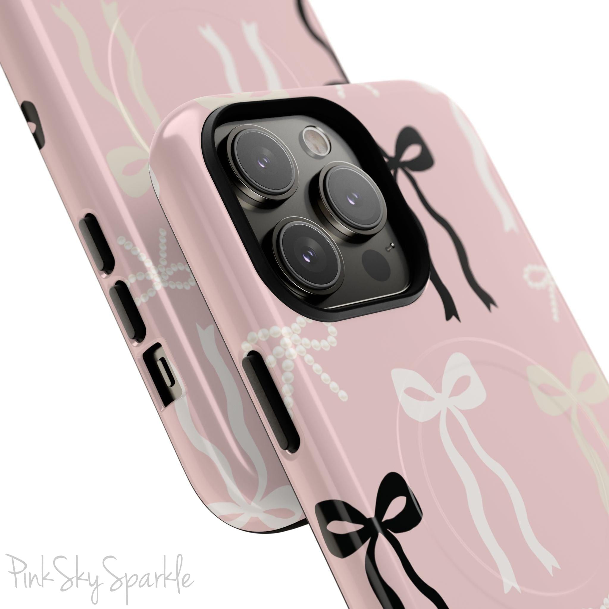 Pink magnetic iPhone case featuring an elegant bow pattern with black, white, and cream bows, designed for MagSafe® compatibility and premium protection.