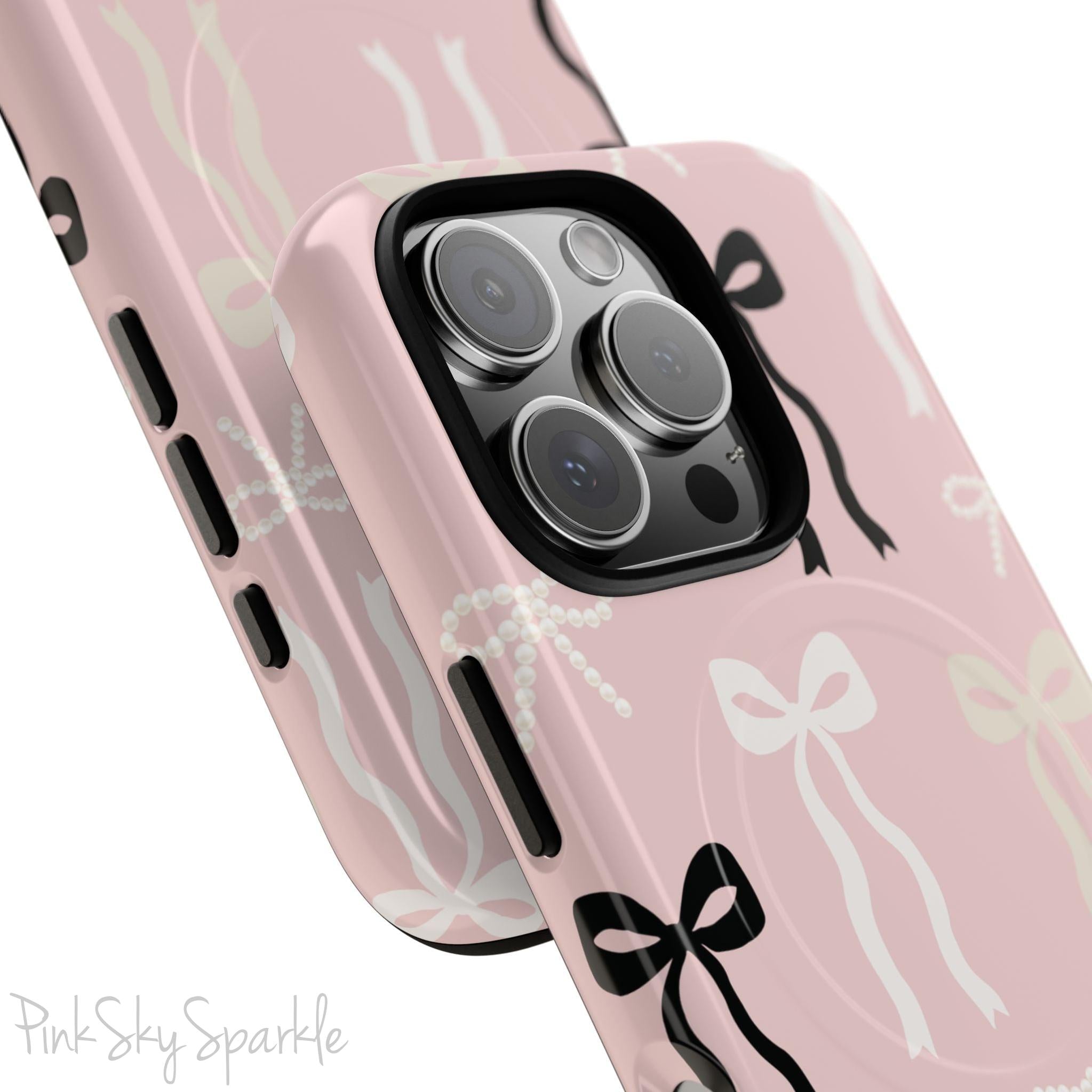 Pink magnetic iPhone case featuring an elegant bow pattern with black, white, and cream bows, designed for MagSafe® compatibility and premium protection.