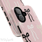 Pink magnetic iPhone case featuring an elegant bow pattern with black, white, and cream bows, designed for MagSafe® compatibility and premium protection.