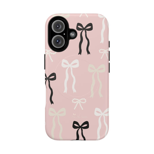 Pink magnetic iPhone case featuring an elegant bow pattern with black, white, and cream bows, designed for MagSafe® compatibility and premium protection.