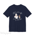 "All I need is coffee and my chihuahua" T-shirt. Featuring a graphic of a woman wearing a robe and hair towel, wearing black sunglasses drinking a coffee next to a chihuahua wearing black sunglasses.