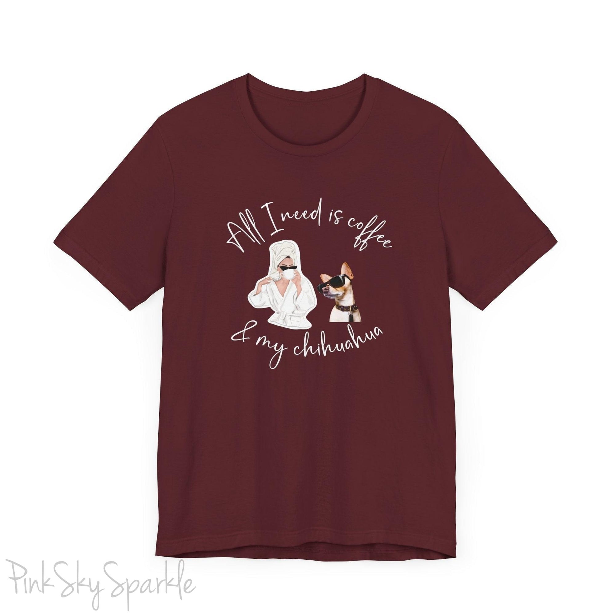 "All I need is coffee and my chihuahua" T-shirt. Featuring a graphic of a woman wearing a robe and hair towel, wearing black sunglasses drinking a coffee next to a chihuahua wearing black sunglasses.
