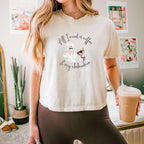 "All I need is coffee and my chihuahua" Women's Boxy Tee. Featuring a graphic of a woman wearing a robe and hair towel, wearing black sunglasses drinking a coffee next to a chihuahua wearing black sunglasses.