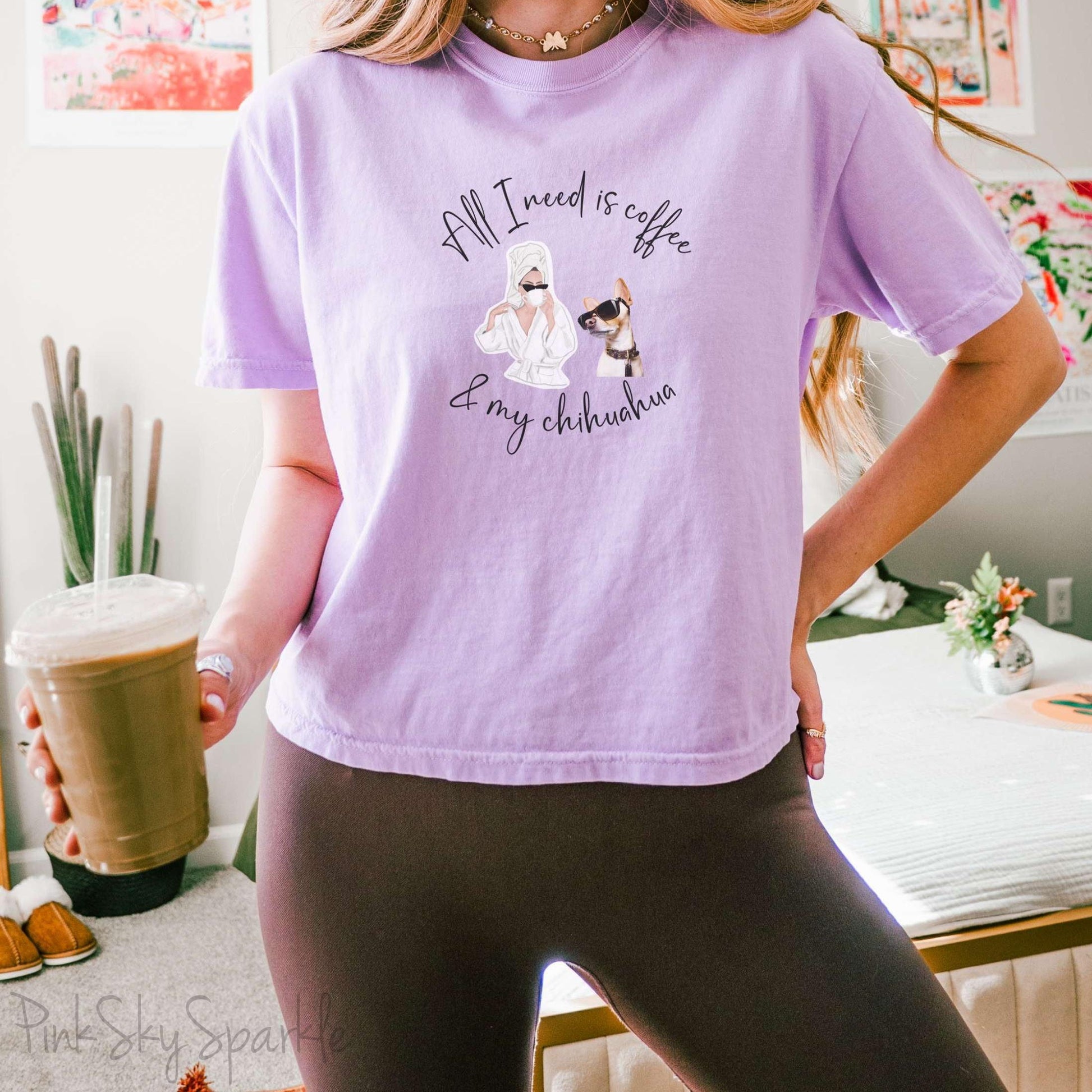 "All I need is coffee and my chihuahua" Women's Boxy Tee. Featuring a graphic of a woman wearing a robe and hair towel, wearing black sunglasses drinking a coffee next to a chihuahua wearing black sunglasses.