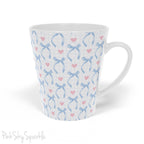 Blue Coquette 12oz Latte Mug,  featuring a light blue gingham print with delicate blue bows and pink hearts, this cute and stylish mug is perfect for your favourite coffee, tea, or hot cocoa. 