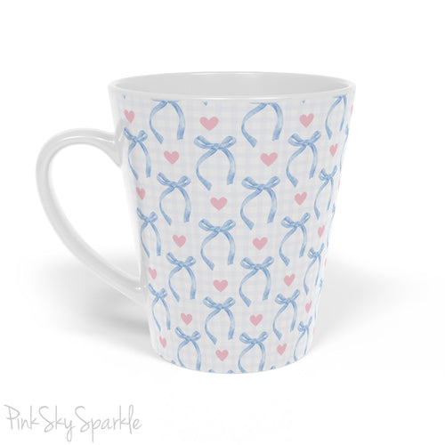 Blue Coquette 12oz Latte Mug,  featuring a light blue gingham print with delicate blue bows and pink hearts, this cute and stylish mug is perfect for your favourite coffee, tea, or hot cocoa. 