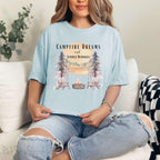 Campfire Dreams and Summer Memories Unisex Garment-Dyed T-shirt. Escape to the great outdoors with our Campfire Dreams and Summer Memories Garment-Dyed T-shirt. Made from soft, high-quality fabric, this shirt is perfect for cozy nights by the fire or creating unforgettable summer memories. Featuring the graphics of a scenery of a sunset, trees, patio lights, a fire pit and two wood chairs.