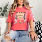 Campfire Dreams and Summer Memories Unisex Garment-Dyed T-shirt. Escape to the great outdoors with our Campfire Dreams and Summer Memories Garment-Dyed T-shirt. Made from soft, high-quality fabric, this shirt is perfect for cozy nights by the fire or creating unforgettable summer memories. Featuring the graphics of a scenery of a sunset, trees, patio lights, a fire pit and two wood chairs.