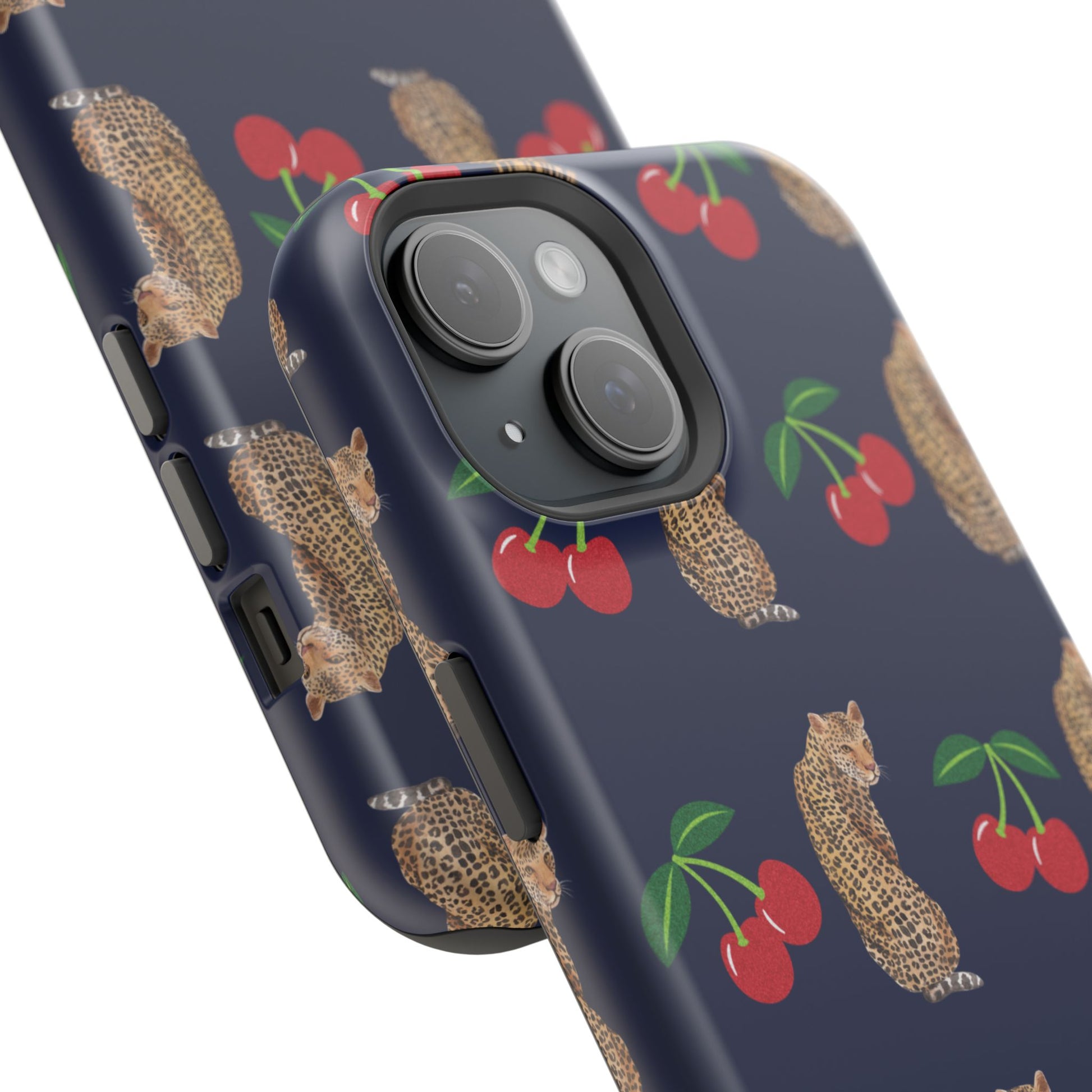 A stylish magnetic iPhone case featuring a unique pattern of leopards and bright red cherries on a dark navy blue background, blending bold and playful elements.