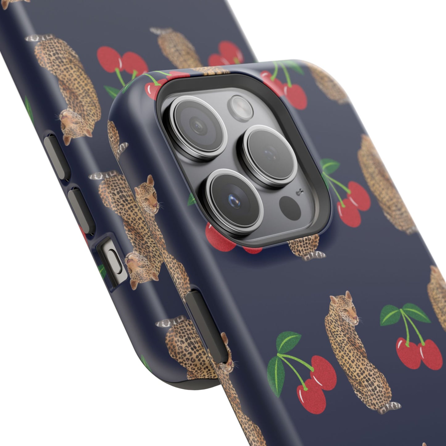 A stylish magnetic iPhone case featuring a unique pattern of leopards and bright red cherries on a dark navy blue background, blending bold and playful elements.