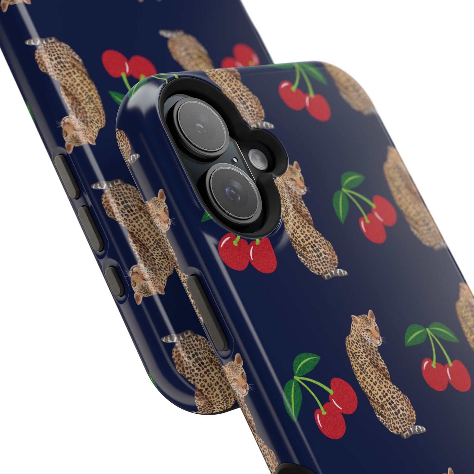 A stylish magnetic iPhone case featuring a unique pattern of leopards and bright red cherries on a dark navy blue background, blending bold and playful elements.