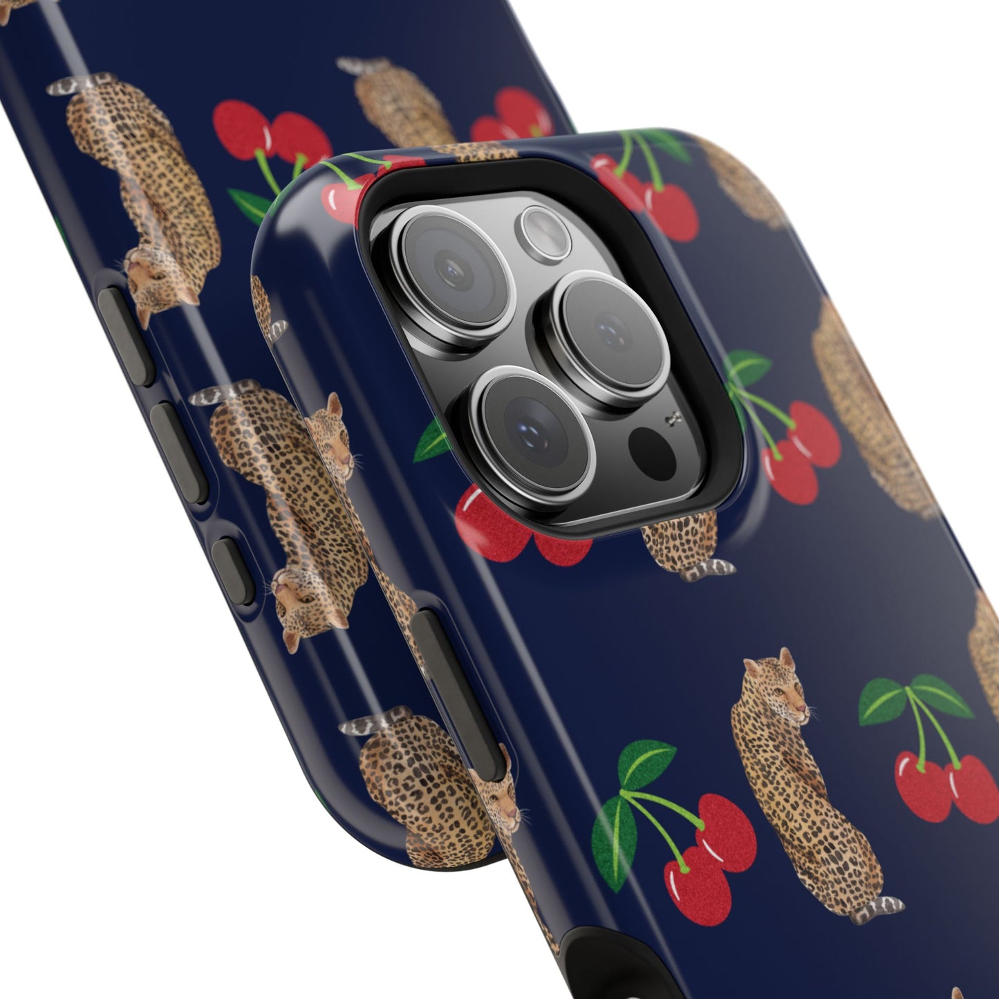 A stylish magnetic iPhone case featuring a unique pattern of leopards and bright red cherries on a dark navy blue background, blending bold and playful elements.