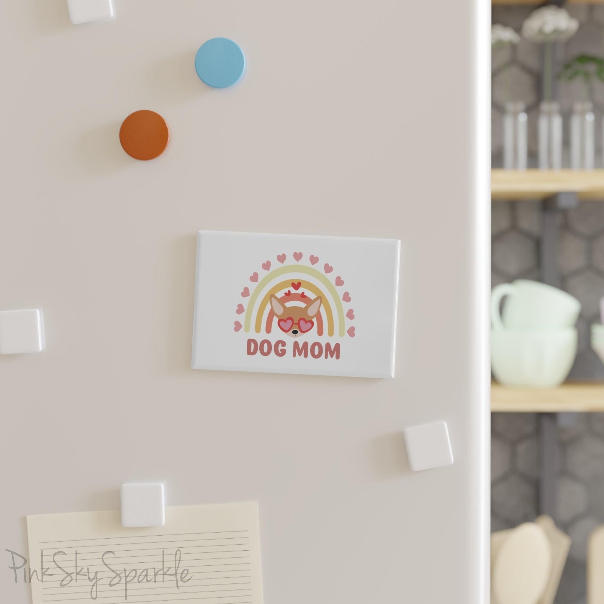 Dog Mom Rainbow & Hearts Rectangle Button Magnet. A white magnet featuring a boho style rainbow with hearts and a chihuahua wearing heart shaped glasses in the center and the words Dog Mom written in all caps below it.