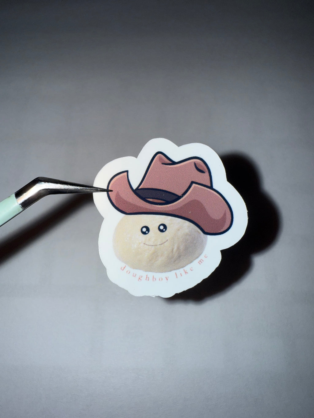 sticker featuring a ball of bread dough with a cowboy hat on with the pun "doughboy like me"