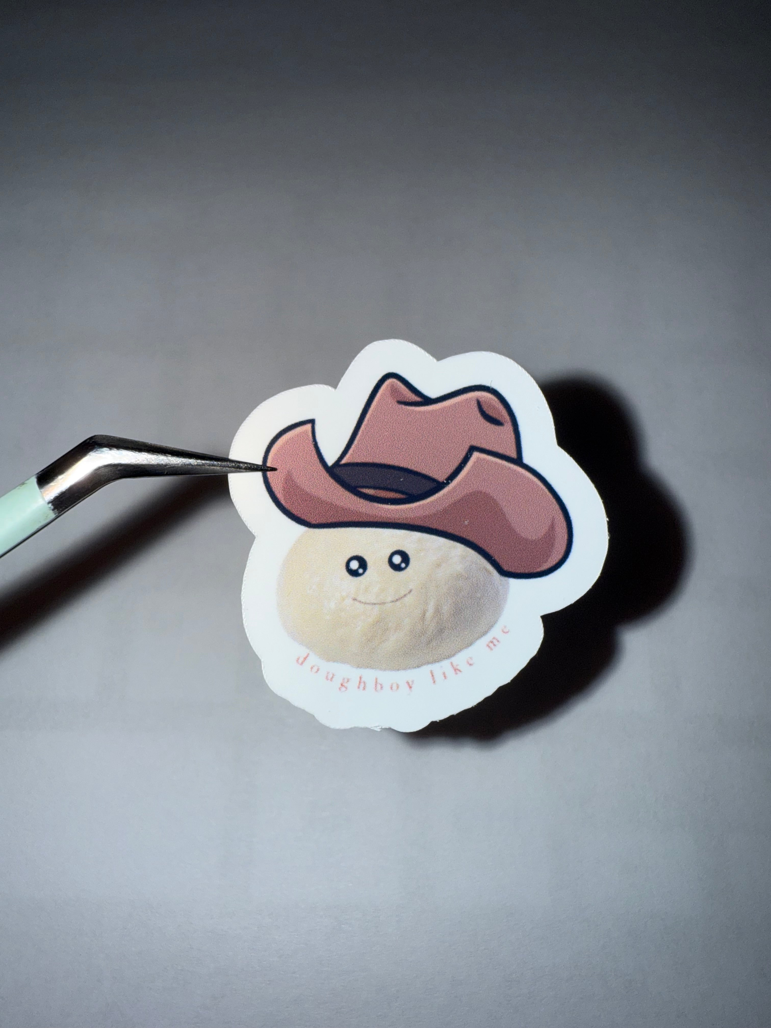 sticker featuring a ball of bread dough with a cowboy hat on with the pun "doughboy like me"