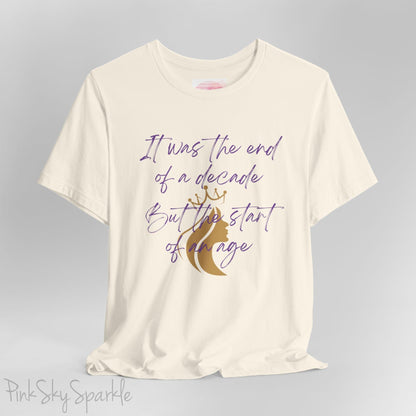 Embrace the excitement of a new era with our End of a Decade, Start of an Age T-shirt, inspired by Taylor Swift's iconic lyrics. Featuring the words It was the end of a decade, But the start of an age in a purple marker script font with a gold silhouette of a woman wearing a crown.