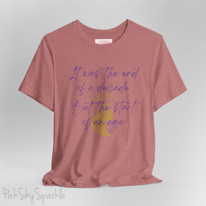 Embrace the excitement of a new era with our End of a Decade, Start of an Age T-shirt, inspired by Taylor Swift's iconic lyrics. Featuring the words It was the end of a decade, But the start of an age in a purple marker script font with a gold silhouette of a woman wearing a crown.