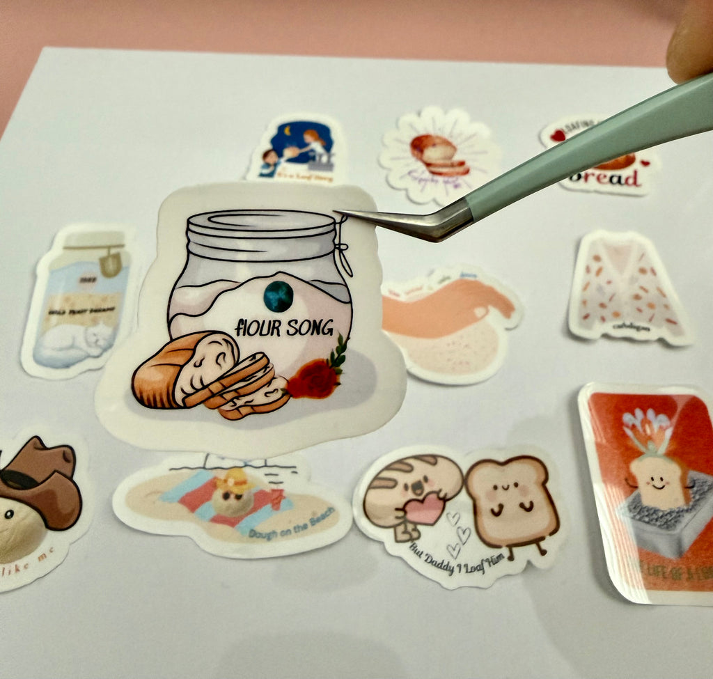 Sticker with a jar of flour, loaf of bread with the pun 'flOUR SONG' on it.