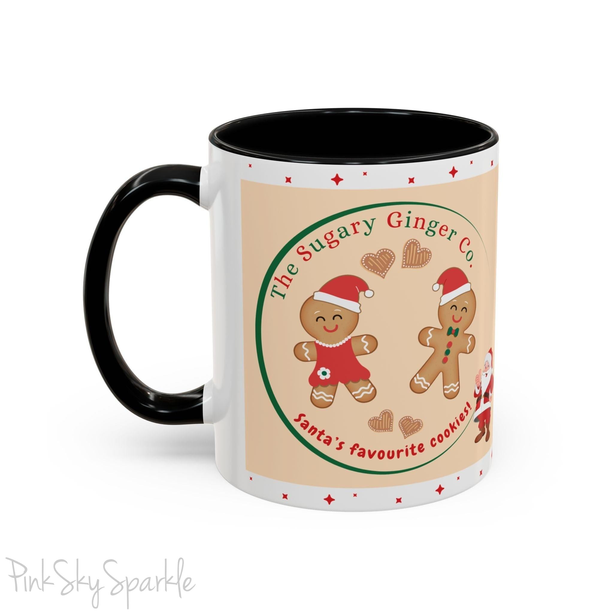 Holiday Gingerbread Coffee Mug featuring a male and female gingerbread cookies next to Santa with giving a thumbs up and the writing The Sugary Ginger Co. written at the top and Santa's favourite cookies at the bottom. The mug has a black handle and black interior. 