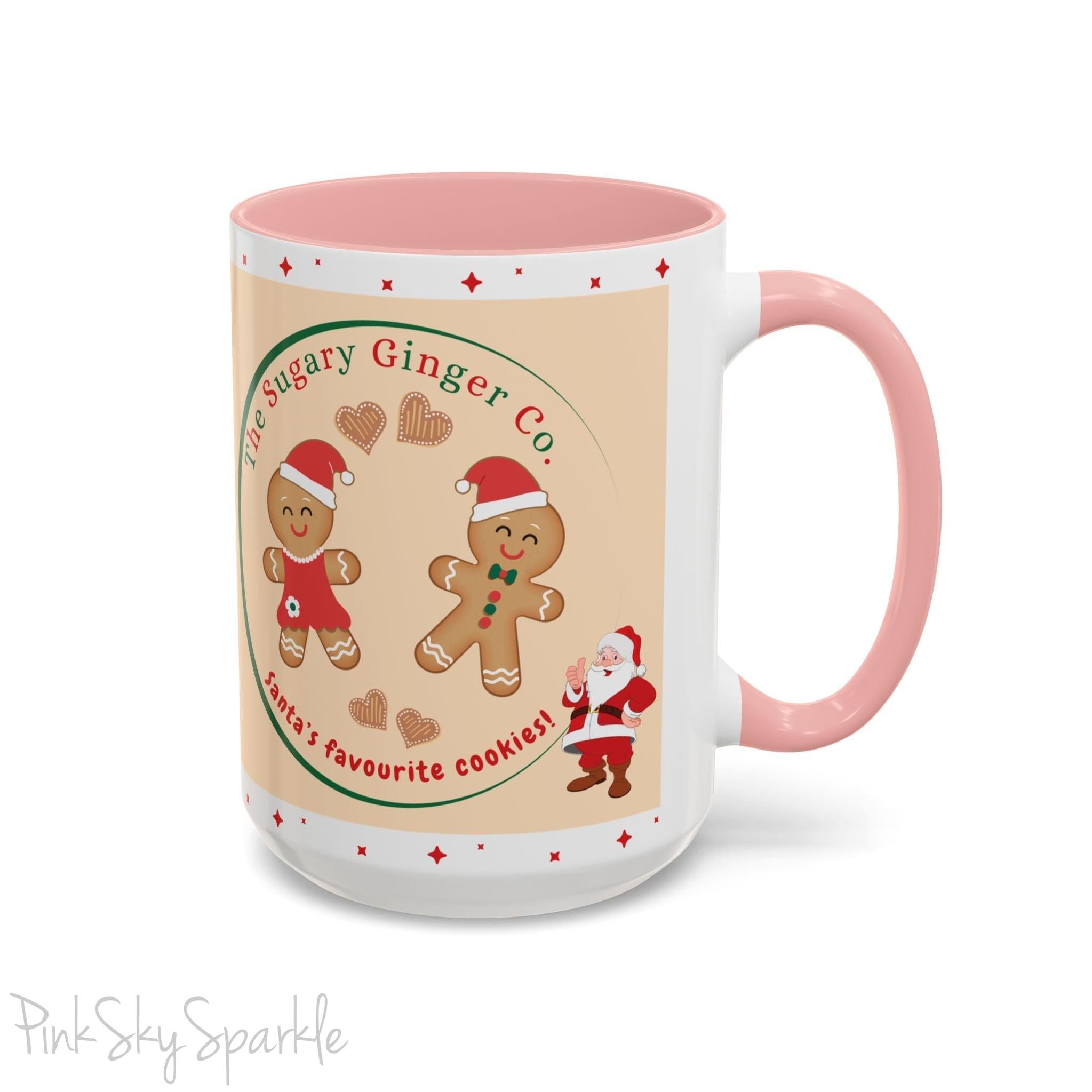 Holiday Gingerbread Coffee Mug featuring a male and female gingerbread cookies next to Santa with giving a thumbs up and the writing The Sugary Ginger Co. written at the top and Santa's favourite cookies at the bottom. The mug has a pink handle and pink interior. 