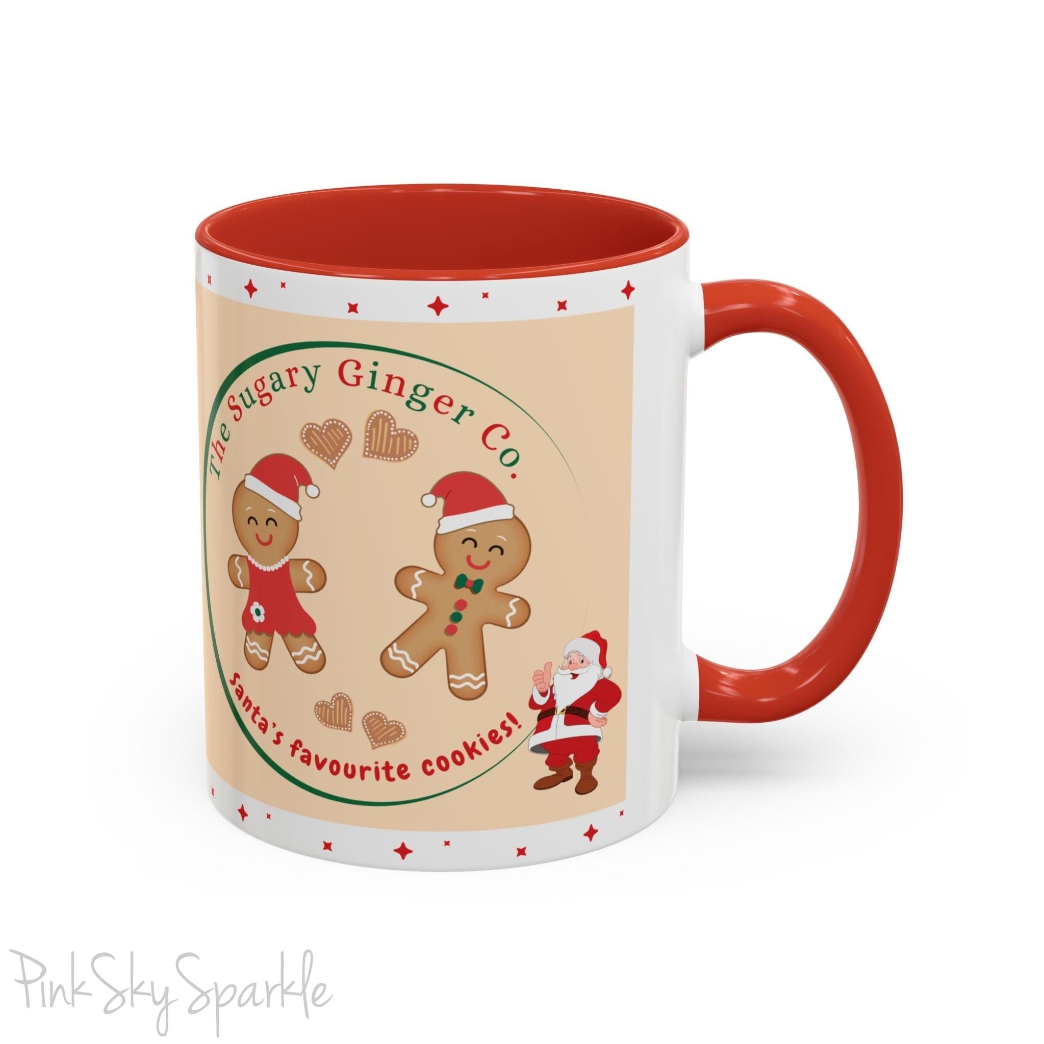 Holiday Gingerbread Coffee Mug featuring a male and female gingerbread cookies next to Santa with giving a thumbs up and the writing The Sugary Ginger Co. written at the top and Santa's favourite cookies at the bottom. The mug has a red handle and red interior. 