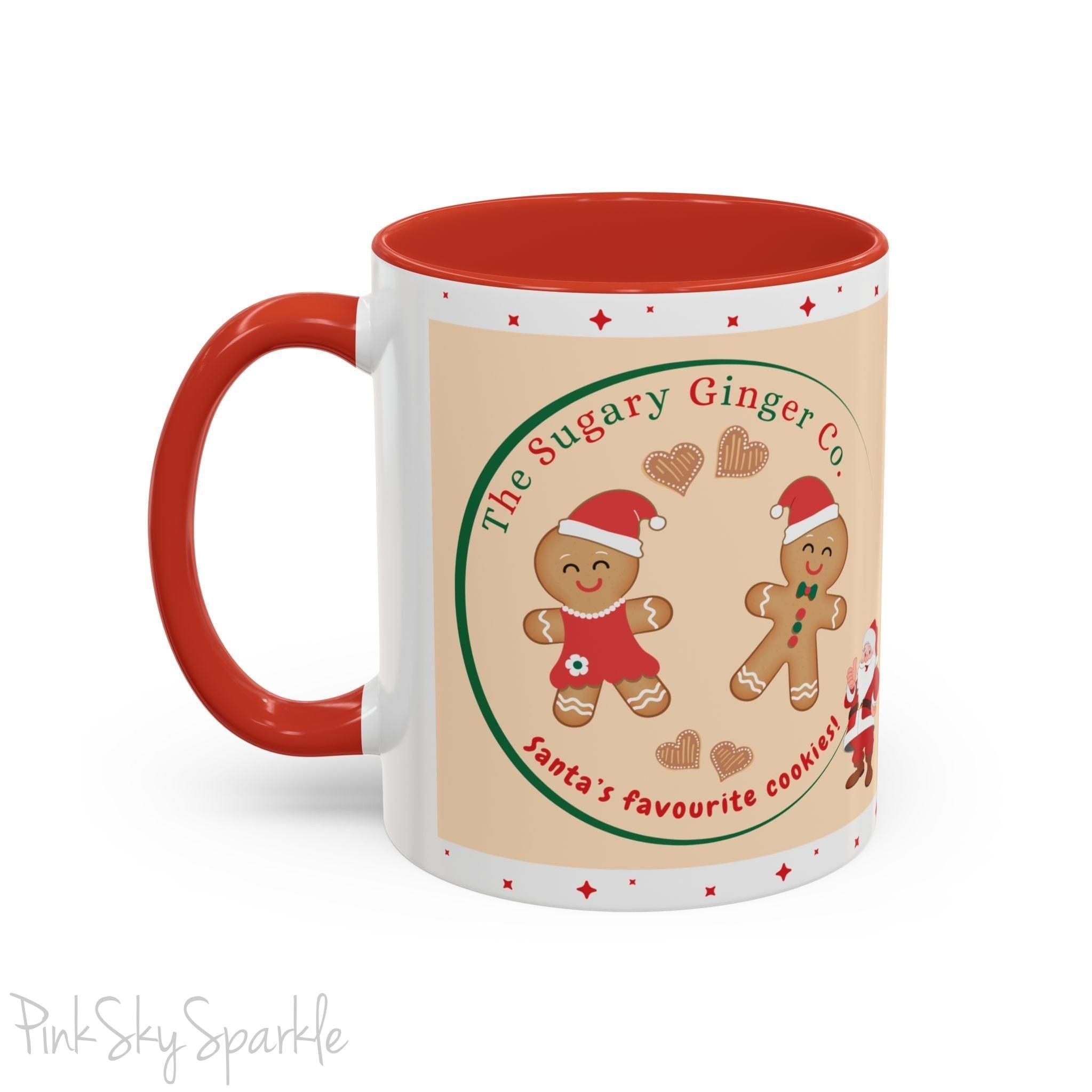 Holiday Gingerbread Coffee Mug featuring a male and female gingerbread cookies next to Santa with giving a thumbs up and the writing The Sugary Ginger Co. written at the top and Santa's favourite cookies at the bottom. The mug has a red handle and red interior. 