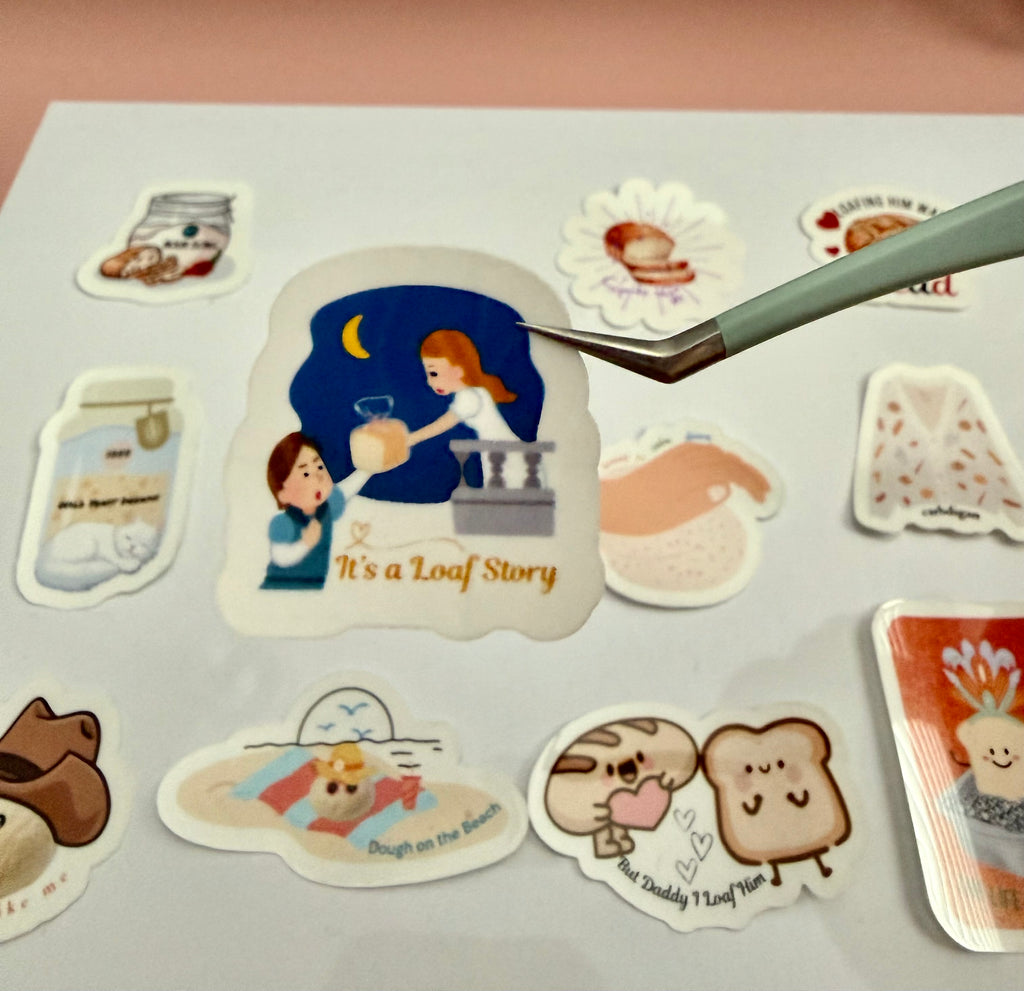 Romeo and Juliet on a sticker, Romeo handing her a loaf of bread and the words 'it's a loaf story' bread pun.