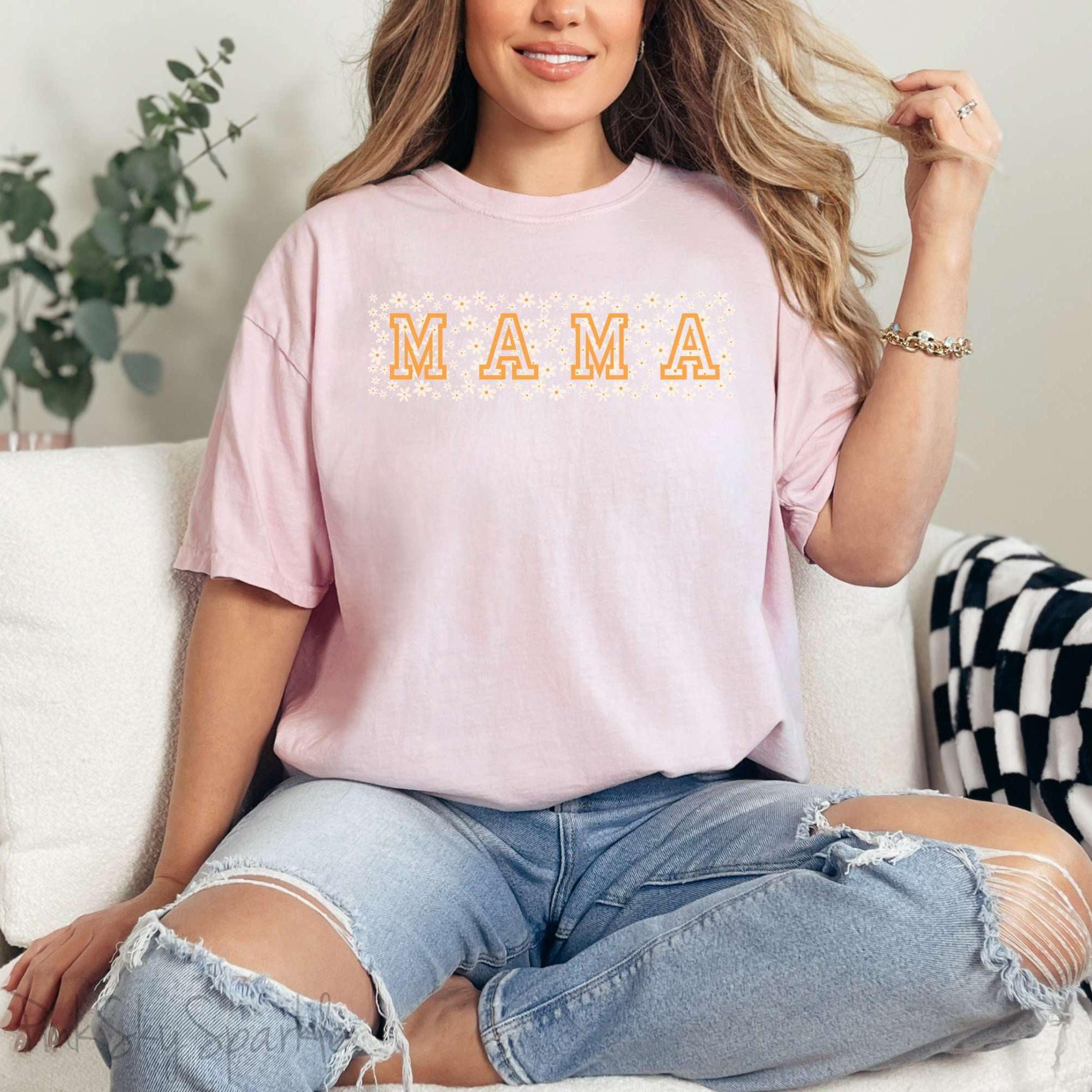 The bold 'MAMA' lettering, overlaid on a charming daisy pattern, makes this shirt a standout piece. Whether you're running errands, meeting friends for coffee, or just enjoying a quiet day at home, this t-shirt is your go-to for effortless style.&nbsp;