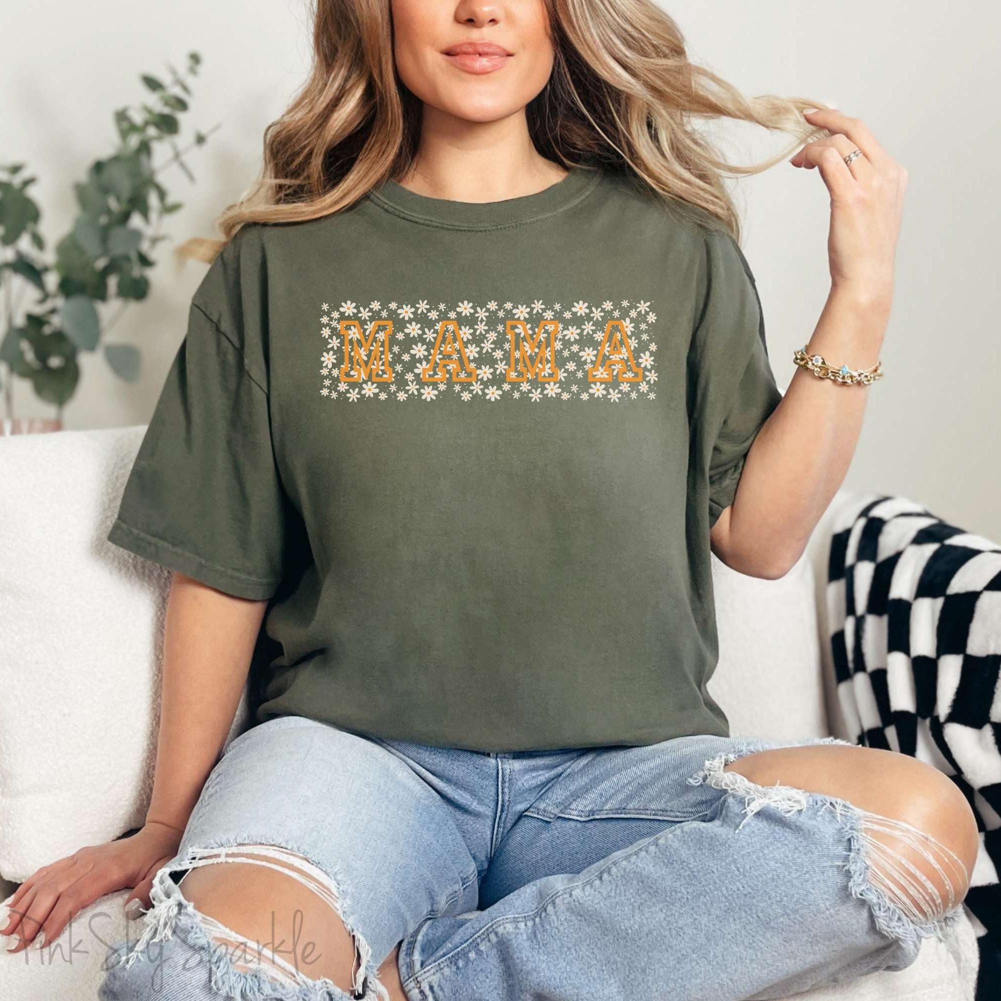 The bold 'MAMA' lettering, overlaid on a charming daisy pattern, makes this shirt a standout piece. Whether you're running errands, meeting friends for coffee, or just enjoying a quiet day at home, this t-shirt is your go-to for effortless style.&nbsp;