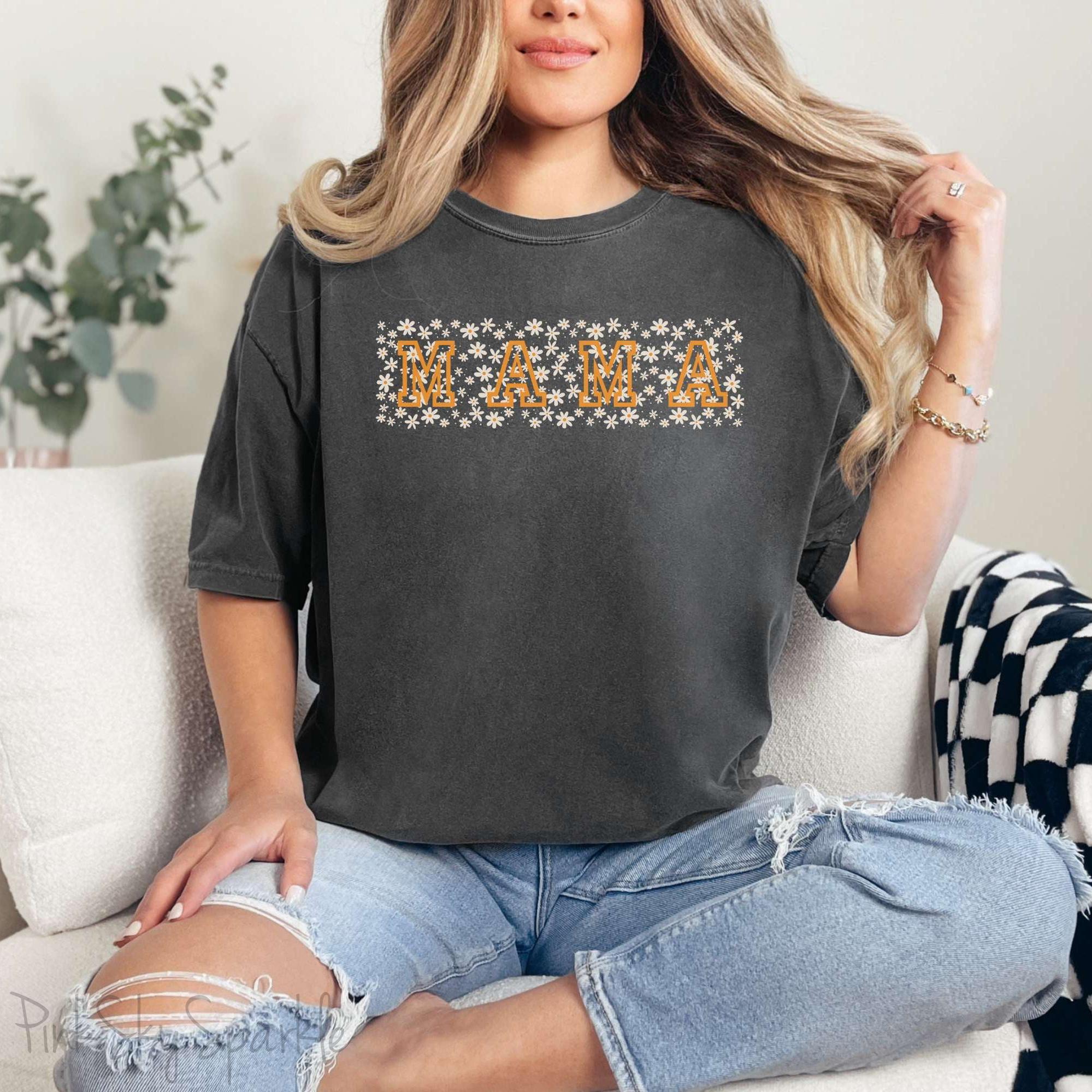 The bold 'MAMA' lettering, overlaid on a charming daisy pattern, makes this shirt a standout piece. Whether you're running errands, meeting friends for coffee, or just enjoying a quiet day at home, this t-shirt is your go-to for effortless style.&nbsp;