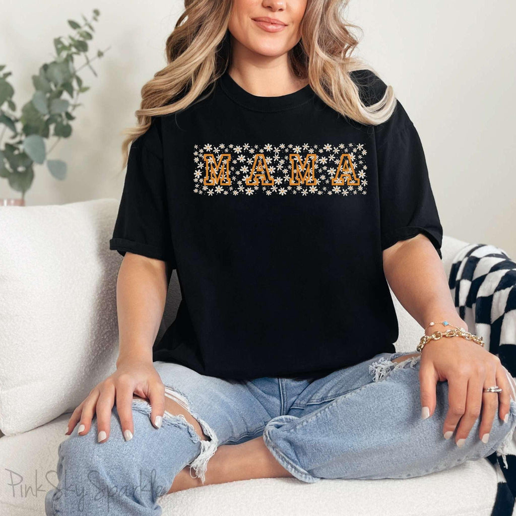 The bold 'MAMA' lettering, overlaid on a charming daisy pattern, makes this shirt a standout piece. Whether you're running errands, meeting friends for coffee, or just enjoying a quiet day at home, this t-shirt is your go-to for effortless style.&nbsp;