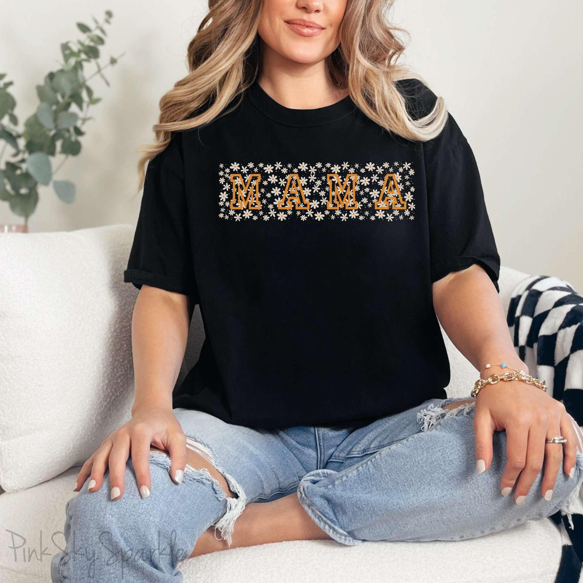 The bold 'MAMA' lettering, overlaid on a charming daisy pattern, makes this shirt a standout piece. Whether you're running errands, meeting friends for coffee, or just enjoying a quiet day at home, this t-shirt is your go-to for effortless style.&nbsp;