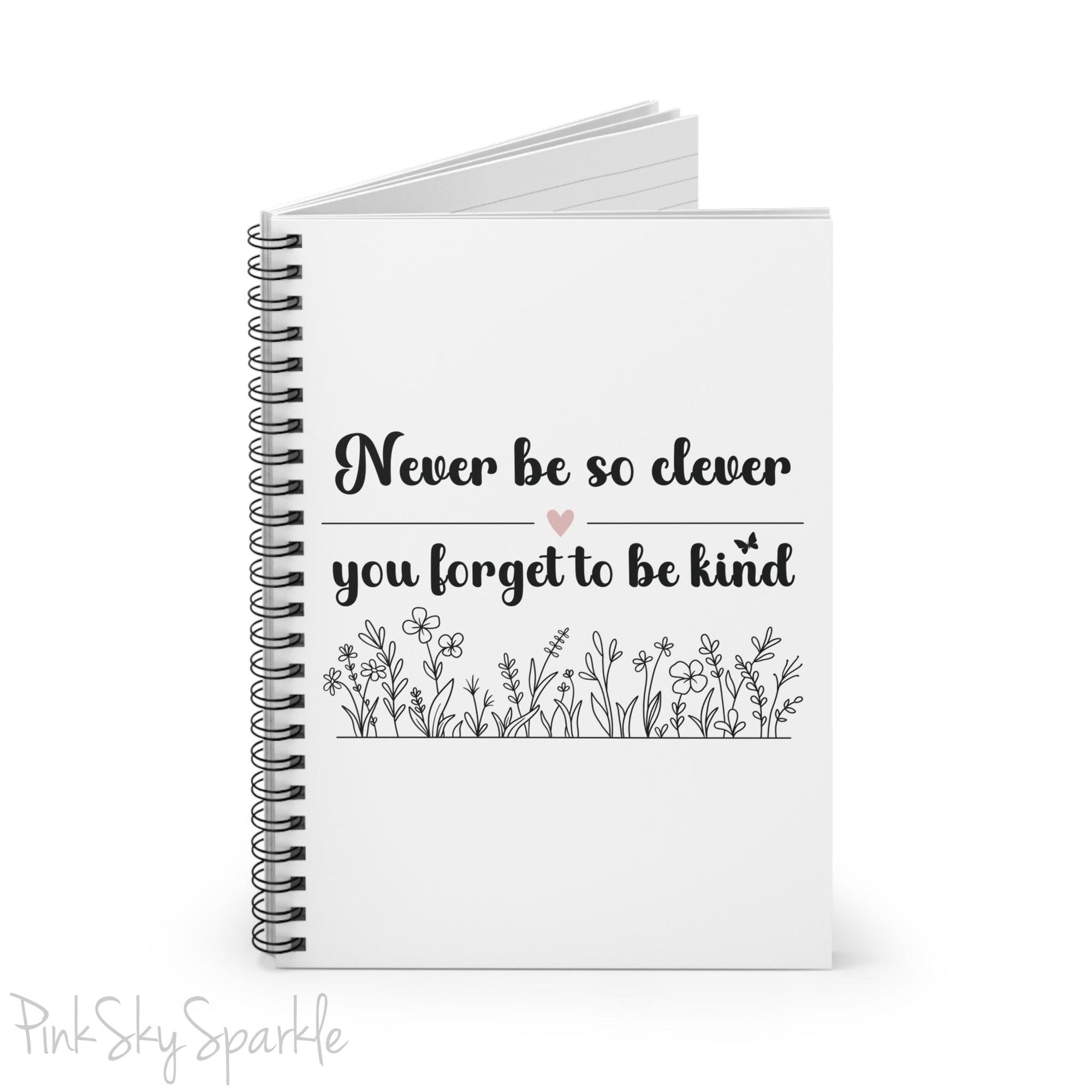 Spiral notebook with the quote "Never be so clever you forget to be kind" and flowers on it.