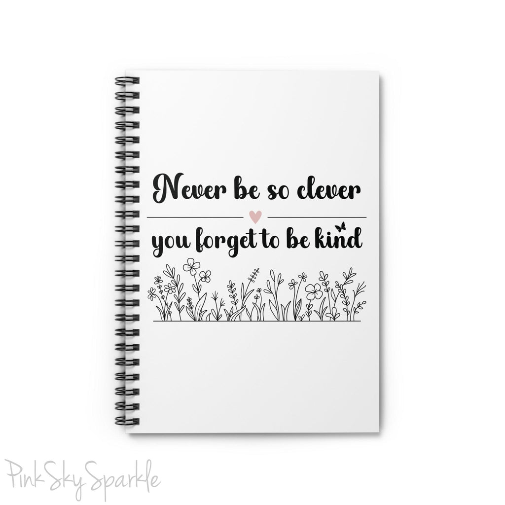 Spiral notebook with the quote "Never be so clever you forget to be kind" and flowers on it.