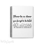 Spiral notebook with the quote "Never be so clever you forget to be kind" and flowers on it.